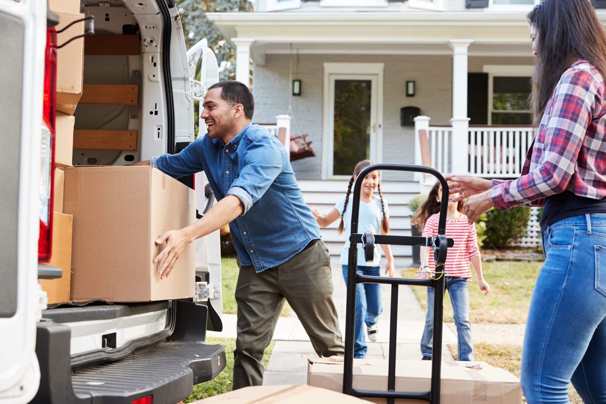 Children,Helping,Unload,Boxes,From,Van,On,Family,Moving,In